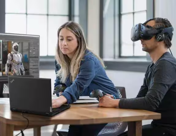 Rear view of Lenovo ThinkPad P15 laptop sitting on a table in front of two individuals using virtual reality equipment